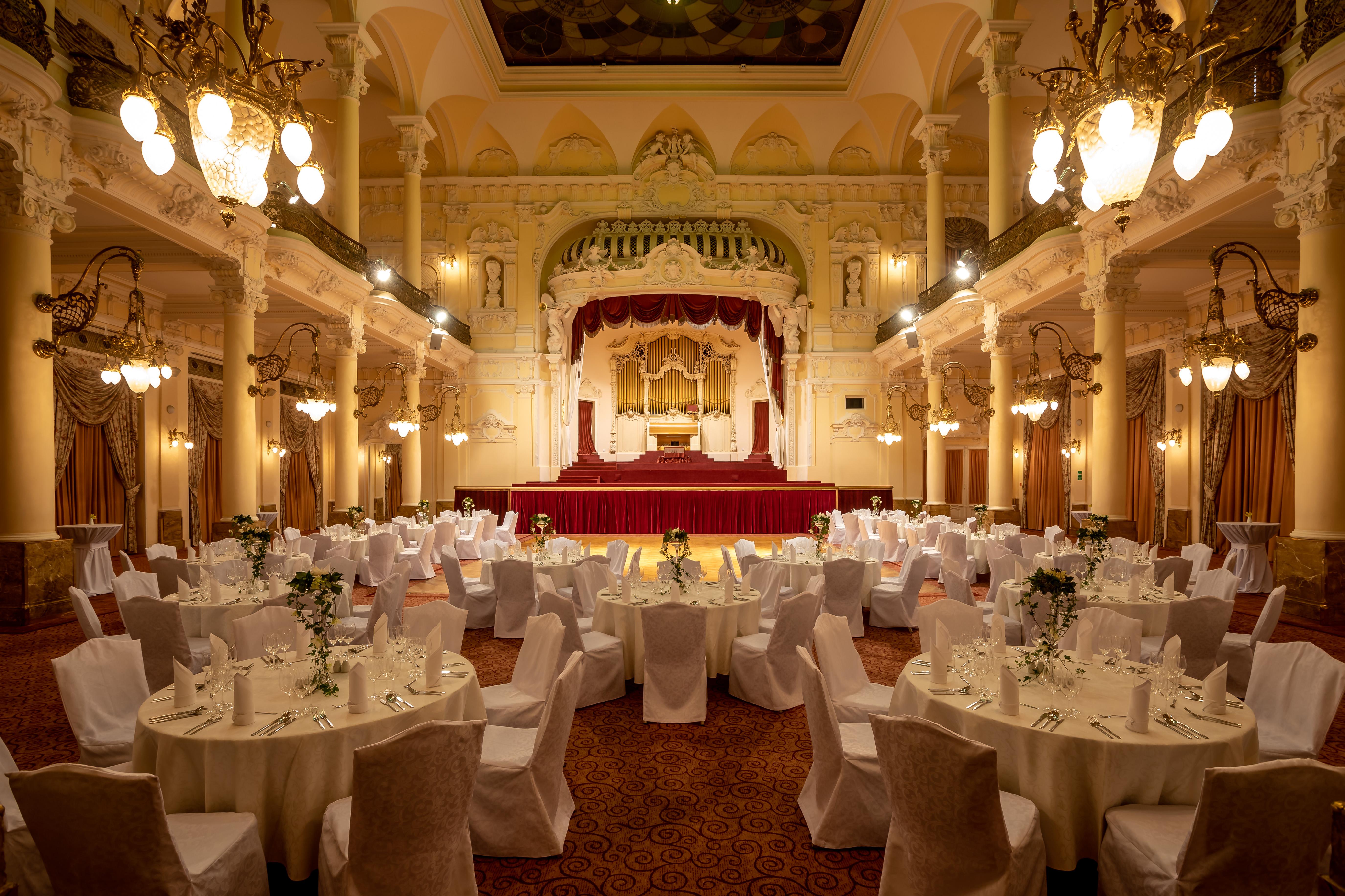 Grandhotel Pupp Karlovy Vary Ngoại thất bức ảnh The photo depicts an elegantly decorated banquet hall. The room features several round tables, each covered with white tablecloths and adorned with floral arrangements. Surrounding the tables are chairs, also draped in white fabric. 

The venue is ch