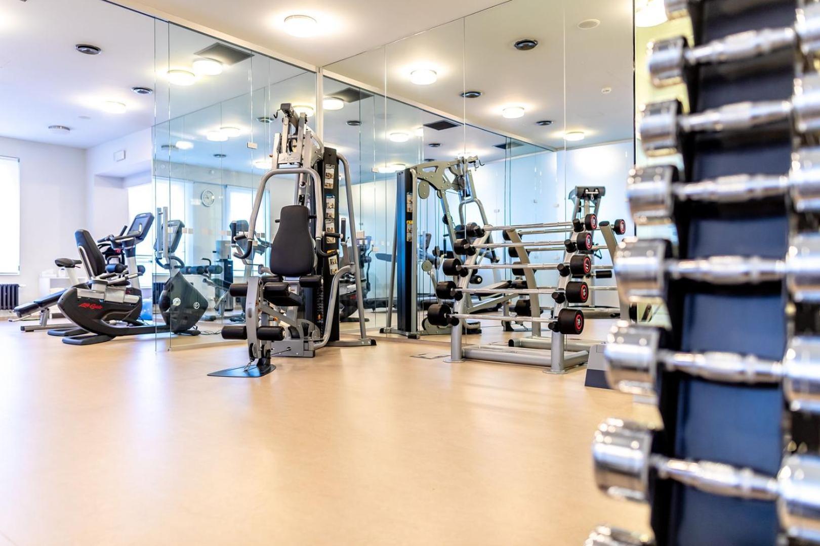 Grandhotel Pupp Karlovy Vary Ngoại thất bức ảnh The photo shows an interior view of a gym or fitness center. In the foreground, there is a rack of dumbbells arranged by weight, highlighting strength training equipment. In the background, various exercise machines are visible, including a stationar