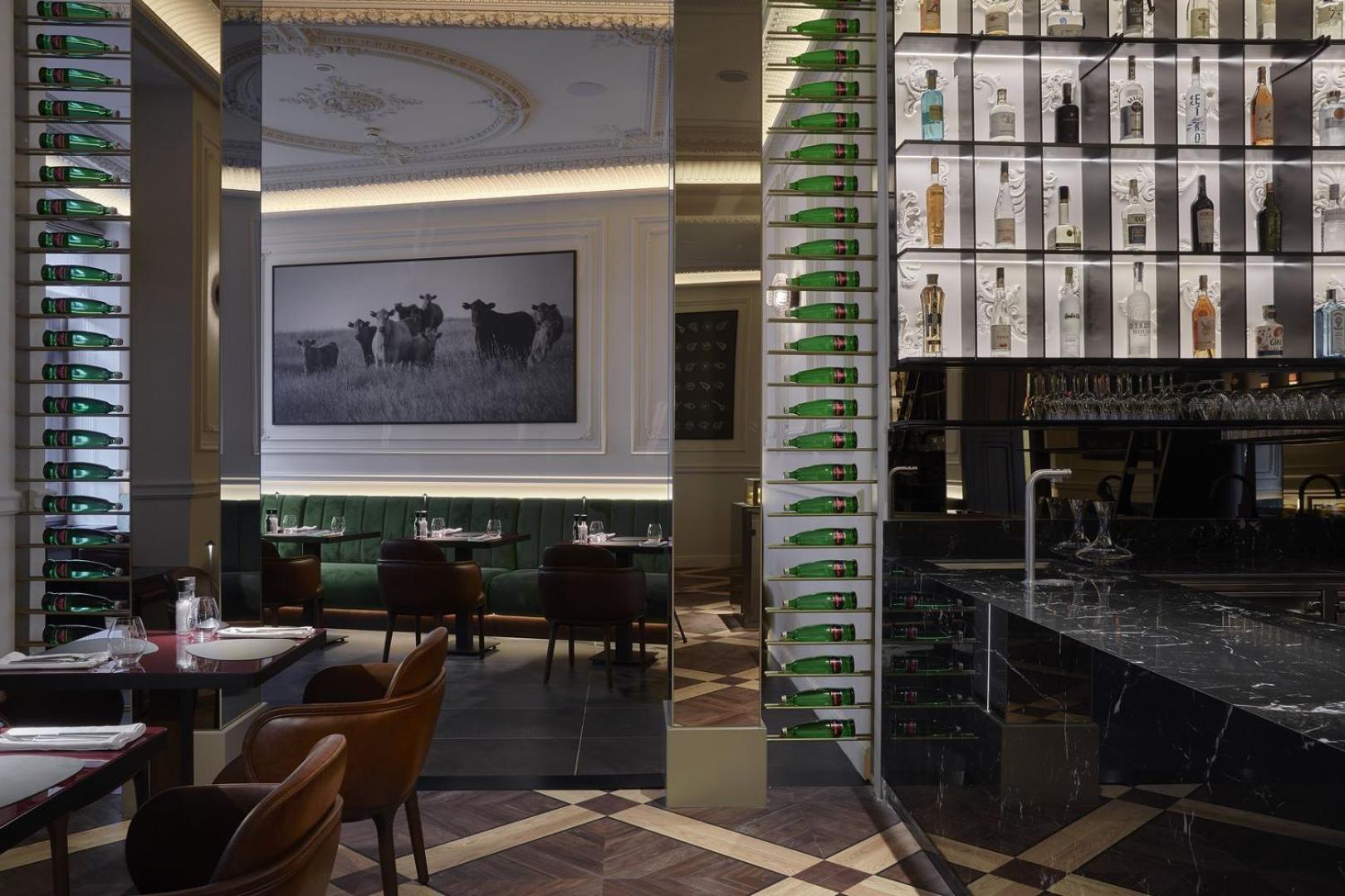 Grandhotel Pupp Karlovy Vary Ngoại thất bức ảnh The photo shows the interior of a stylish restaurant. There is a large photograph of cows on the wall, adding a rustic touch to the decor. The space features elegant seating with dark brown chairs, and the tables are set for dining. A bar area is vis